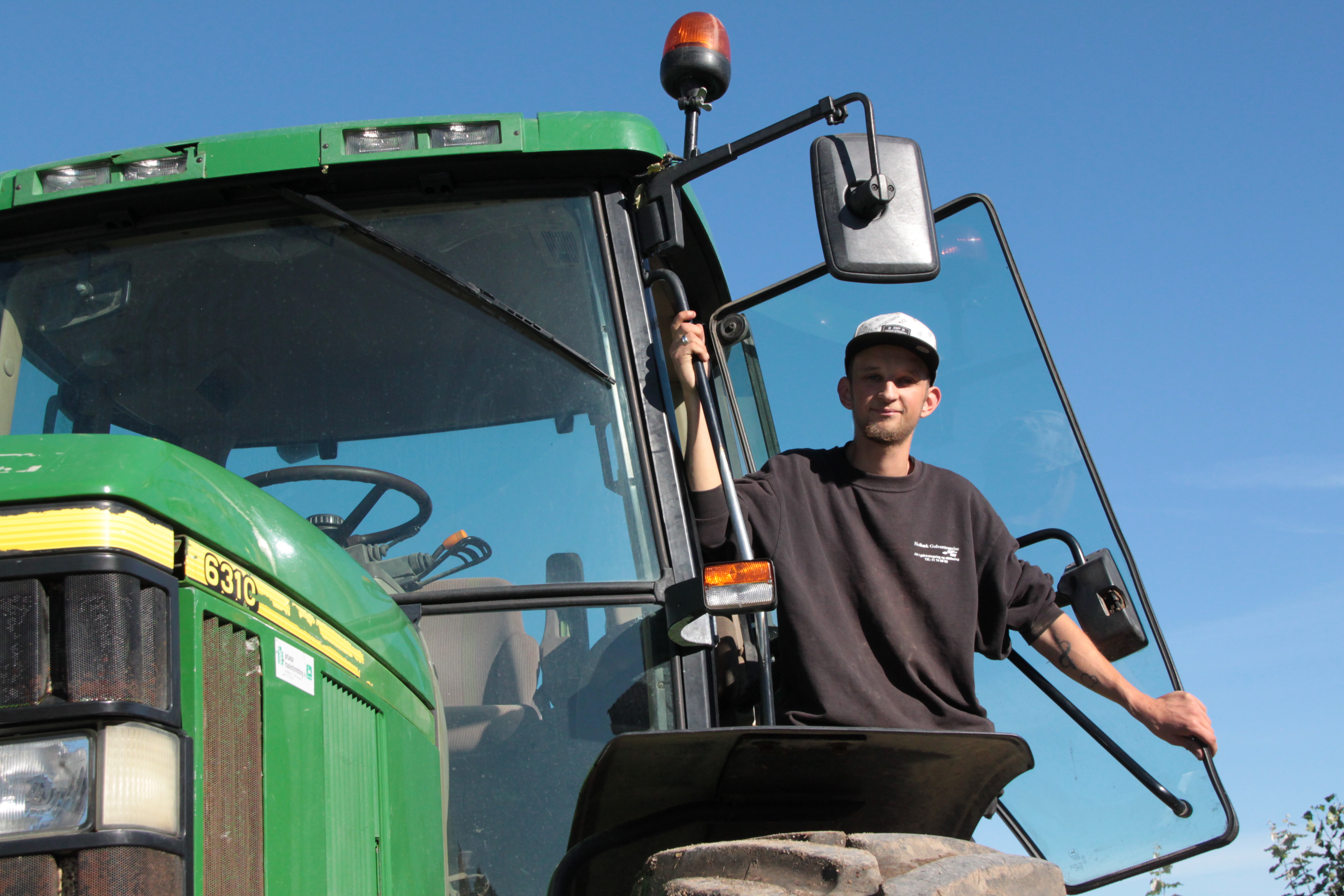 Landmand i døren til traktor.